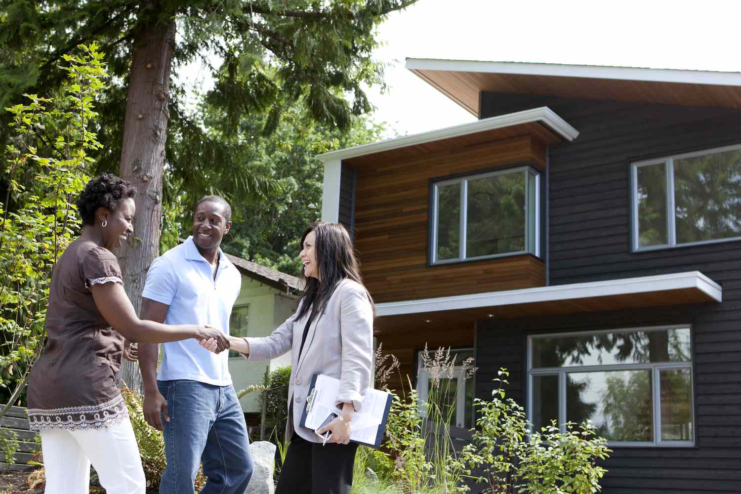Homeowners discussing a property sale outside a residential home